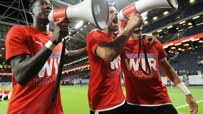 Austrian players Martin Harnik, centre, and David Alaba, left, celebrate with fans after qualifying for Euro 2016 on Tuesday with a win over Sweden. Robert Jaeger / EPA / September 8, 2015