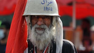 An Iraqi protester wears a helmet with Iraq marked on it in blue in during a gathering in Baghdad's landmark Tahrir Square, two days after the first anniversary of the start of nationwide mass demonstrations against the government. AFP