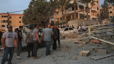 People gather at the site of an Israeli air strike in Tayr Debba. AFP
