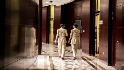 Two police officers walk down a corridor.