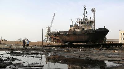 Workers inspect damages at the site of an air strike on the maintenance hub at the Hodeidah port. Houthi rebels handed over control of a vital port of Hodeidah to government forces as part of a peace deal that was reached in Stockholm in December last year, but fighting has continued in the city since. AFP