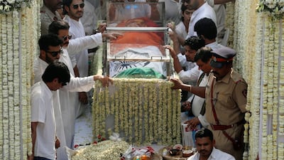 Friends and family members stand next to the body of Bollywood actress Sridevi draped in Indian national flag during her funeral procession in Mumbai, India. Reuters