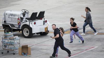 People run on the tarmac at Fort Lauderdale’s Hollywood International Airport after a gunman opened fire in a baggage claim area on January 6, 2017. Wilfredo Lee / AP Photo