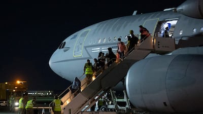 Passengers from Afghanistan leave a British Royal Air Force plane after landing at RAF Brize Norton station in southern England on August 24. AFP