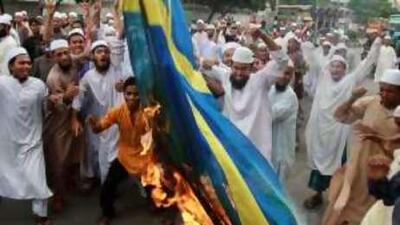 Protesters burn a Swedish flag during a protest in Dhaka, Bangladesh, against Facebook over a competition that featured caricatures of the Prophet Mohammed.