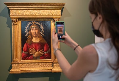 A visitor takes a photograph of 'The Man of Sorrows' at Sotheby's Dubai. Ryan Lim for The National