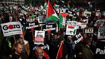Pro-Palestinian activists and supporters wave flags and carry placards during a march through London, on Saturday. AFP