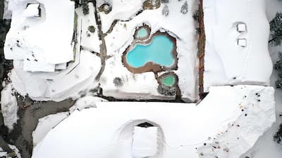 Workers remove snow from the roofs of a hotel in the Sierra Nevada mountains. AFP