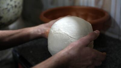 Dough being prepared to make garnished flatbread. AFP