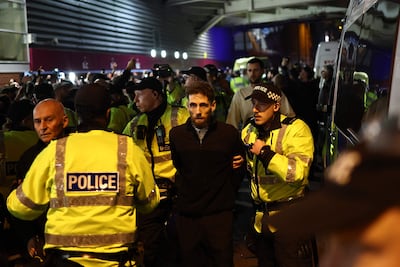 Police officers detain a man outside Villa Park. AFP