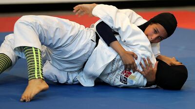 Balqees Al Hashmi, top, and Meena Al Mazroori train at Zayed Sports City in Abu Dhabi. Pawan Singh / The National