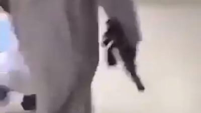 A screenshot of a video posted by Al Riyadh showing a student carrying a rifle at school.