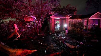 Standing on the porch of a damaged home in the aftermath of the tornado. AP Photo