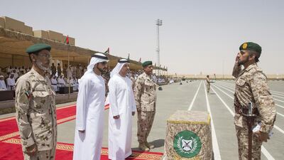 Sheikh Ahmed bin Mohamed bin Rashid (R), salutes Sheikh Hamdan bin Mohammed, Crown Prince of Dubai, Sheikh Hazza bin Zayed, Vice Chairman of the Abu Dhabi Executive Council (3rd L) and Lt Gen Hamad Thani Al Romaithi, Chief of Staff UAE Armed Forces (L), after receiving an award during a ceremony to mark the 40th anniversary of the Armed Forces unification, and the graduation of the 5th batch of National Service personnel, at the Seeh Al Hama camp. Mohammed Al Hammadi / Crown Prince Court - Abu Dhabi