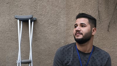 Ali Salam Jassem describes is leg as hanging "like a feather" after being shot during protests late last year. Ameer Hazim for The National