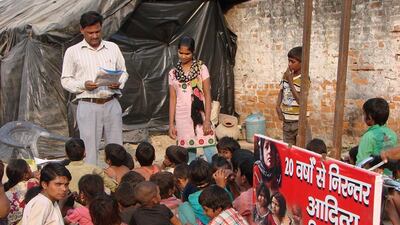 Indian teacher Aditya Kumar, left, teaches children at a makeshift school in Lucknow in an effort to reach slum children - some of the country's most deprived communities. Nishant Saxena/AFP Photo