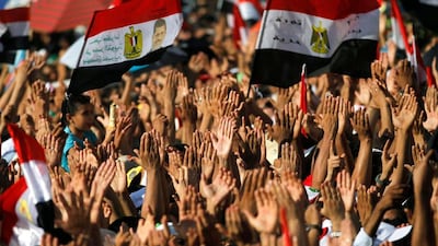 Egyptians raise their hands and chant slogans as they gather for a speech by President-elect Mohammed Morsi in Tahrir Square in Cairo, Egypt, Friday, June 29, 2012. In front of tens of thousands of cheering supporters, Egypt's first Islamist and civilian president-elect vowed Saturday that nobody can take away his authority and symbolically read an oath of office in Cairo's Tahrir Square on the eve of his official inauguration. (AP Photo/Khalil Hamra)