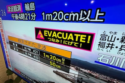 A tsunami warning is shown on TV in Yokohama. AP