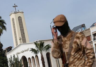 A rebel fighter guards on the street in front of a church "Lady of Damascus" in Damascus, Syria December 11. Reuters