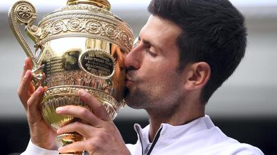 Serbia's Novak Djokovic kisses the winner's trophy after beating Roger Federer in 2019. AFP
