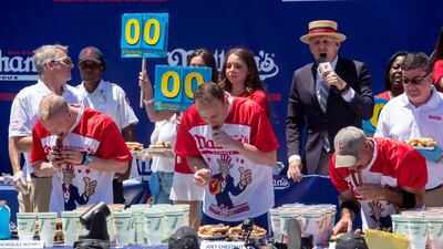 Top male competitive eaters from left, Nick Wehry, Joey Chestnut and Geoffrey Esper eat their first hot dogs and buns. EPA