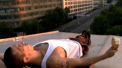 A Russian runner watches the sunset while eating a stolen bread roll.