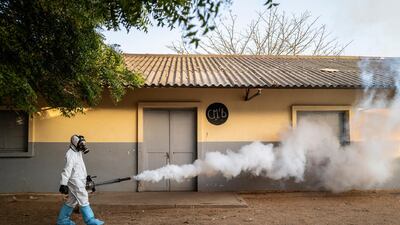 A municipal worker sprays disinfectant at a school in Dakar, Senegal. AP Photo