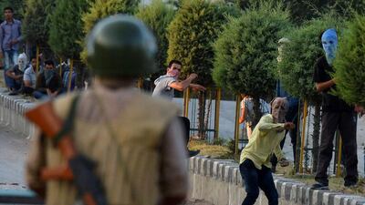Kashmiri protesters throw stones after Indian paramilitary troops fired tear gas during clashes in Srinagar. Tauseef Mustafa / AFP
