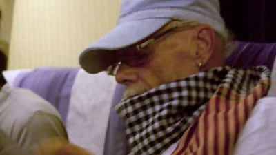 Gary Glitter sits on a flight after his release from prison yesterday.