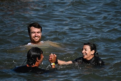 Paris Mayor Anne Hidalgo (R) and her deputy in charge of sanitation Antoine Guillou (L) swim in the Seine, in Paris on July 17, 2024, to demonstrate that the river is clean enough to host the outdoor swimming events at the Paris Olympics later this month. (Photo by JULIEN DE ROSA / AFP)