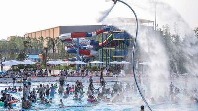 People watch a flyboard performance as they cool off in a pool to escape the hot weather at a water park in Huaian, in China's eastern Jiangsu province. AFP