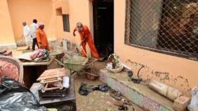 Government cleaners remove sludge from the homes in Sharam village in Fujairah after it was hit by flash floods on Monday.