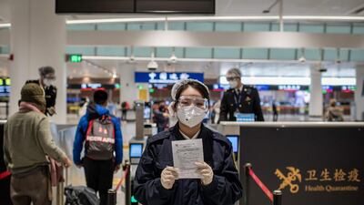 A health quarantine officer holds a health document to be filled and signed by arriving passengers in the wake of the the COVID-19 coronavirus outbreak at Daxing international airport in Beijing. AFP