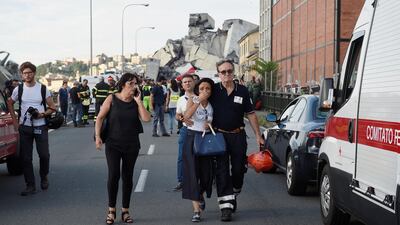 A woman cries while being embraced by a fire fighter as she leaves the site of the collapsed Morandi Bridge. Reuters