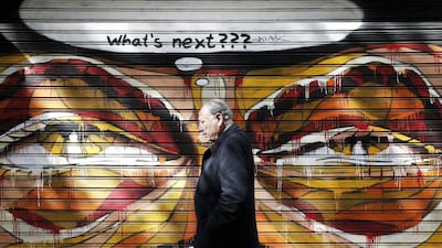 A man walks past graffiti in Athens on February 25, 2015. Germany's finance minister Wolfgang Schaeuble said on Wednesday it had not been an easy decision for euro zone finance ministers to extend the Greek rescue plan by four months and much doubt remained about how credible Athens' latest reform commitments really were. Alkis Konstantinidis / Reuters