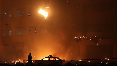 Debris falls from a high-rise building as a fire spreads up the side of the building in Ajman. Kamran Jebreili / AP