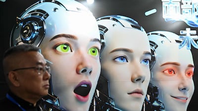 A visitor stands by a poster showing robots mimicking human expressions from Shenzhen Xiaoquan Technology during the International AI Application and Robotics Innovation Exhibition in Beijing. AFP