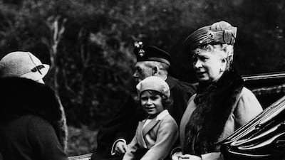 Queen Elizabeth seated between her grandfather King George V and grandmother Queen Mary of Teck as they ride in a carriage back to Balmoral Castle in 1935. Getty Images