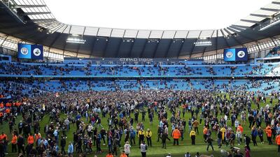 Manchester City fans invade the pitch after winning the Premier League match against Swansea City at Etihad stadium in Manchester. Nigel French / AP Photo