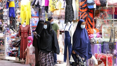 Shoppers walk outside stores in Dubai on May 5, 2021 after it opened following the breaking of the fast during the Muslim holy fasting month of Ramadan. / AFP / Karim SAHIB