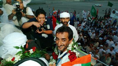 Sheikh Ahmed bin Hasher is received by a crowd of cheerful Emiratis upon arriving in Dubai on 26 August 2004. AFP