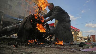 A Syrian man stands next to a burning motorcycle at the site of a car bomb explosion in the northern Syrian Kurdish town of Tal Abyad. AFP