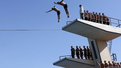 Egyptian police cadets dive into a pool.