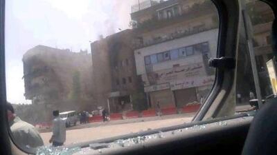 This citizen journalist image shot through a broken car window shows smoke billowing from a building after fighting between rebels and Syrian troops in the Yarmouk camp for Palestinian refugees in Damascus.
