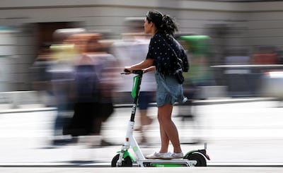 A woman rides on an electric scooter in Berlin on 18 July, 2019. The city has embraced the scooters since they were legalised in June. EPA