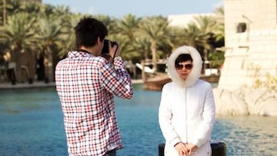 Kazakhstan tourist Nursultan Sajanova takes a photo of his bundled mother, Raushan Sajanova at Souk Madinat Jumeirah.