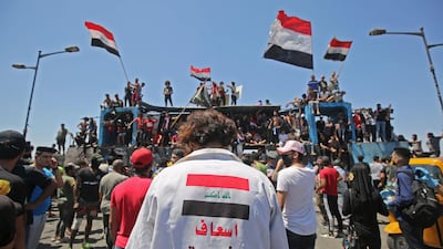 Iraqi protesters wave national flags during an anti-government demonstration on Al Jumhuriyah bridge in the capital Baghdad. AFP