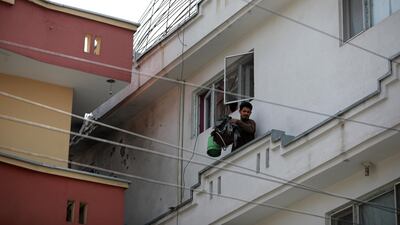 A man exits his house after its roof was hit by a rocket, in Kabul, Afghanistan. EPA