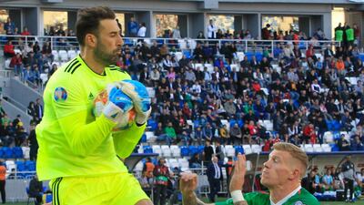 Georgia goalkeeper Giorgi Loria catches the ball under pressure from James McClean of Ireland. AP