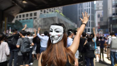 A woman wearing a Guy Fawkes mask joins people taking part in a protest against a potential government ban on protesters wearing face masks in Hong Kong on October 4, 2019. AFP